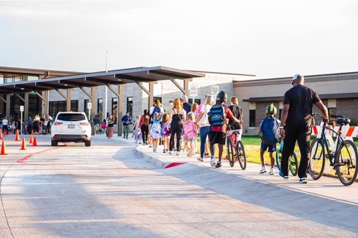 students walk toward a school building