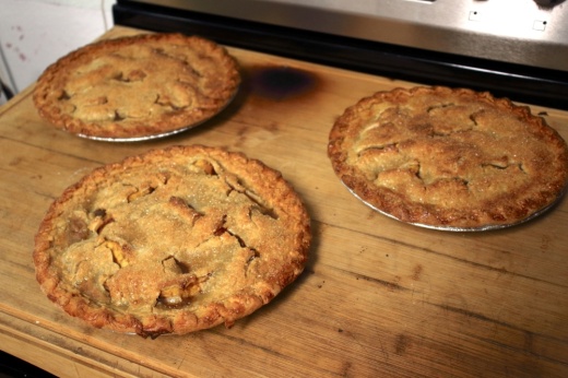 three homemade pies on a cutting board