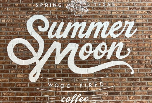 The interior of the new Summer Moon Coffee location features the logo on a brick wall. The company opened a new location in Nassau Bay. (Courtesy Summer Moon Coffee)