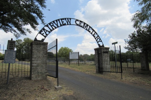 A road into a cemetery with an arch reading fairview cemetery