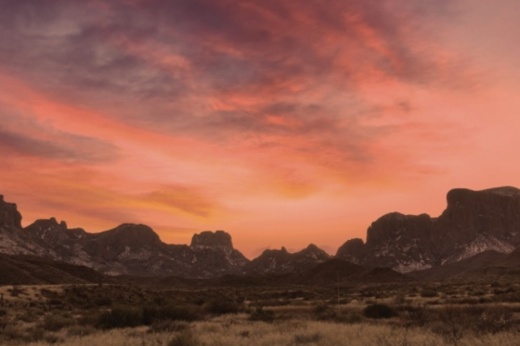 this image depicts a landscape with an orange sky background and cliffs