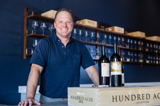 Founder Gabe Anderson poses with bottles of wine in the facility.
