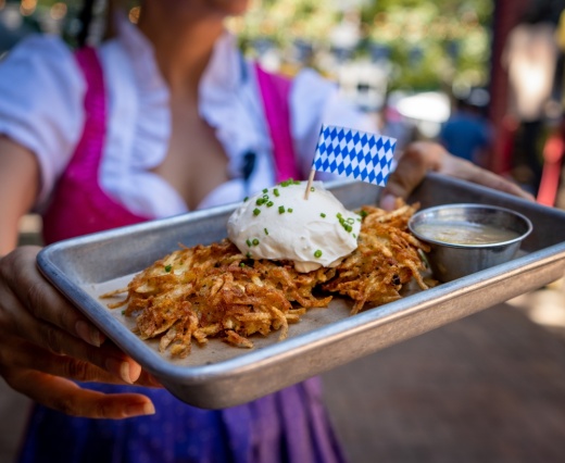 A woman holds a tray of German food.