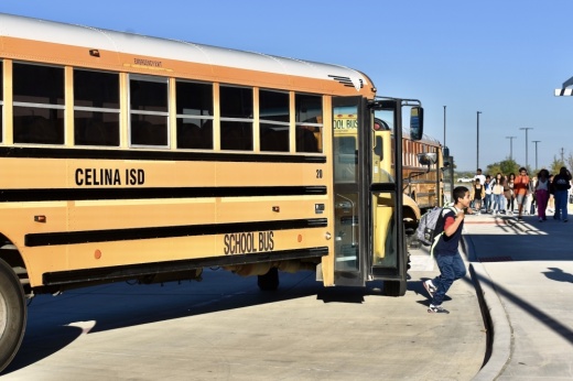 a students walks away from a yellow school bus