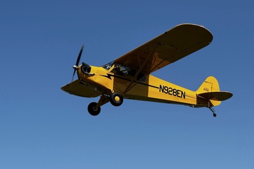 a yellow airplane flying in the air