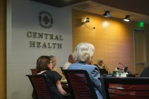 people sitting in chairs in Central Health board room