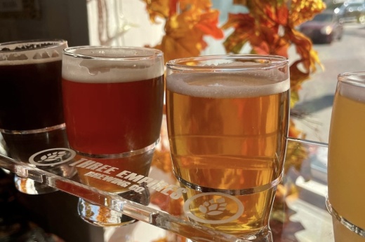 a line of beer on a three empires brewing tray