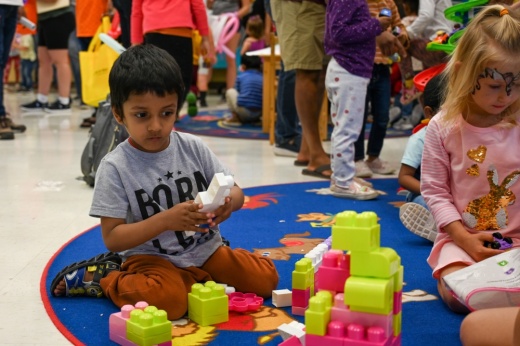A prekindergarten student plays with large legos.
