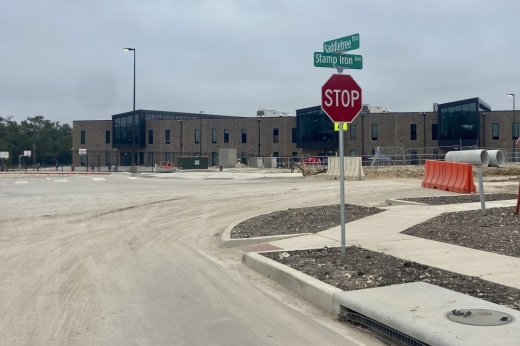 Two streets intersect at a stop sign in front of an elementary school