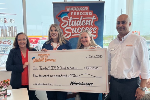 The photo shows Whataburger representatives presenting a check to Tomball ISD leaders.