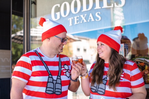 Two people in Waldo costumes tasting beer.