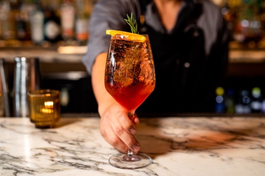 person holding an aperol spritz
