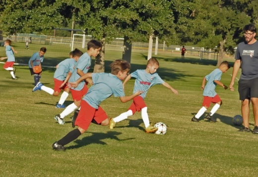 A photo of youth soccer players practicing in the park