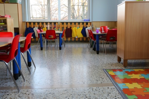 a room for child care, with small tables and chairs, and some toys on a table