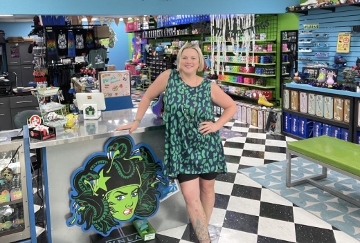 A woman stands in front of the sales counter inside the skate shop.