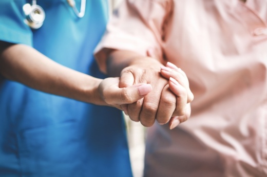 Doctor holds a patients hand.