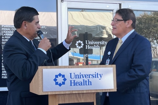 University Health President and CEO George B. Hernández Jr. accepts a challenge coin from Converse Mayor Al Suarez. (Tricia Schwennesen/Community Impact)