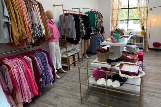 interior of a store with clothing on racks, mannequins and tables
