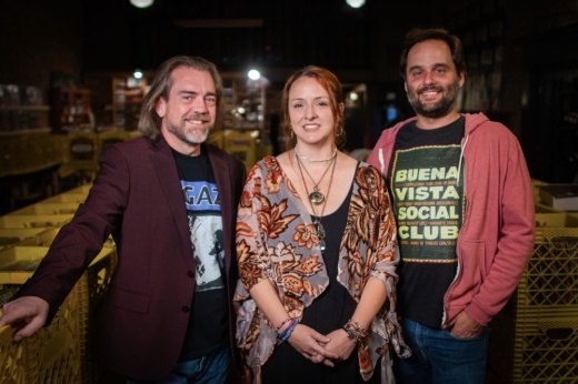 Three adults standing in a record store.