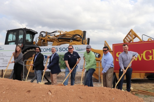 New Braunfels officials post with shovels in mounds of dirt.