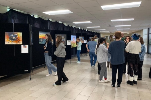Students look at artwork in a high school hallway