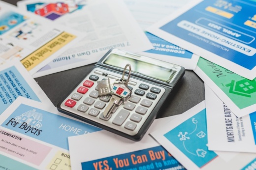 Stock photo of keys on a calculator, which in on a pile of home buying documents.