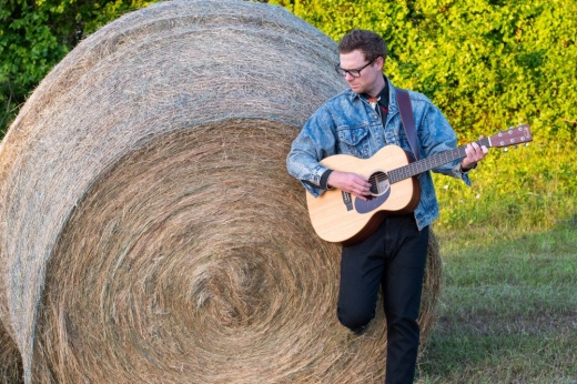 Todd Youngblood standing in front of a hay bale.