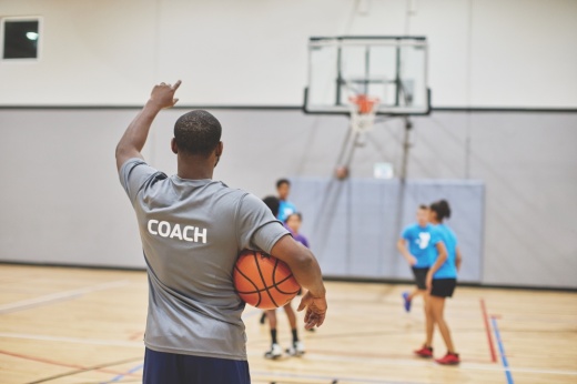 The photo shows a basketball coach at the YMCA.