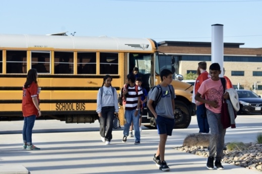 students walk off of a school bus