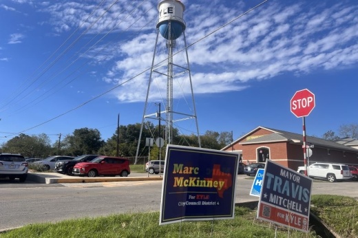 Campaign signs staked into the ground in front of the Kyle water tower.