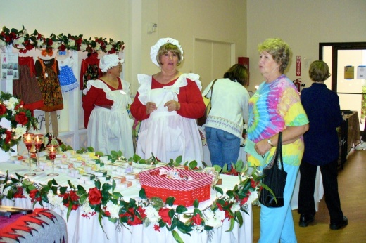Table decorated with Christmas colors and ladies dressed in Christmas colors