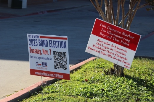 Election Day signs in grass near cburg at Denton South Branch Library.