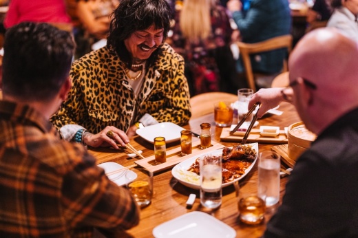People sit at a table with some of RedFarm's dishes on display.
