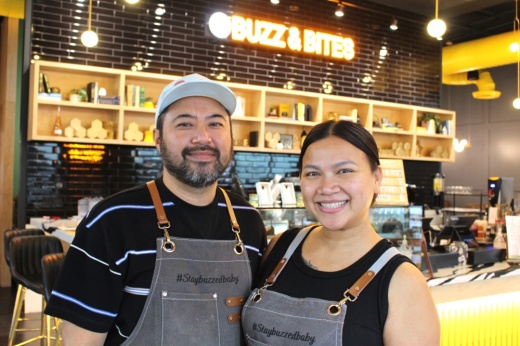 two people smiling for a photo inside a business