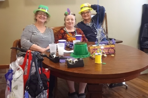 three senior women gathered around a table for a celebration