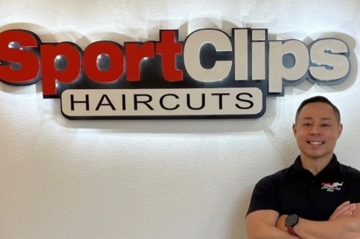 Franchisee standing in front of a Sport Clips sign