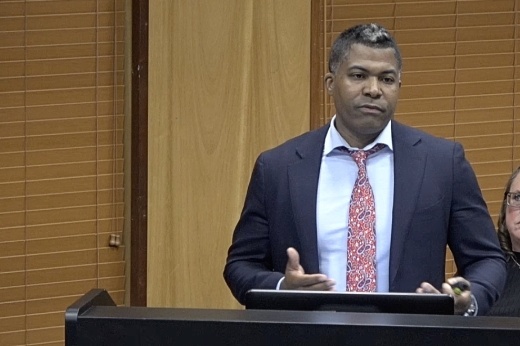 Man stands at podium to present plans to city council.