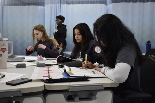 three students work at their desk