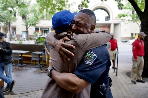 APD Lt. Lee Davis embraces Raasin McIntosh, vice president of active urbanism for the Downtown Austin Alliance, at an Oct. 23 event one month after APD implemented added safety measures downtown. (Courtesy Downtown Austin Alliance)
