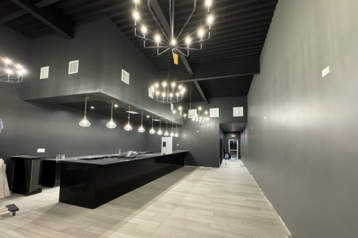 an elegant black bar with chandelier lights