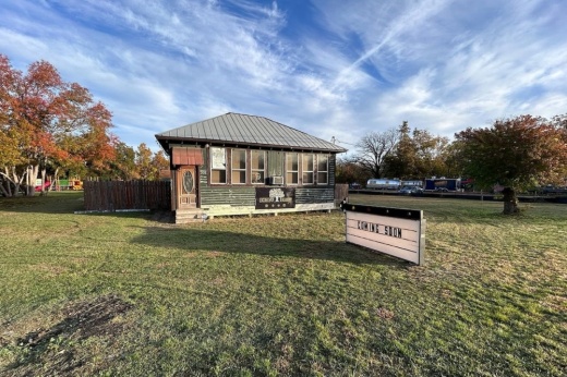 open green space with marquee sign and small building