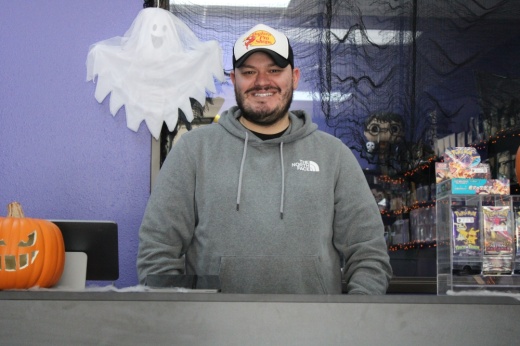 Ryan Rush behind the counter of Lord Rush Collectibles