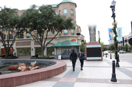 Two visitors walking around in Sugar Land Town Square.