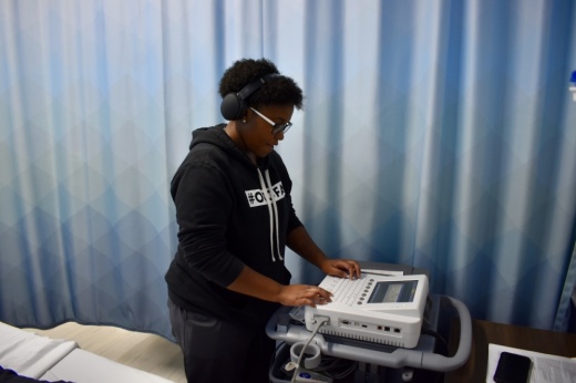 a student stands by a medical machine