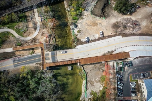 Aerial view of recently completed elevated pedestrian bridge and newly reopened road.