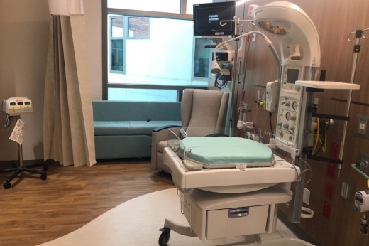 A look inside one of the rooms shows a window looking outside, a blue pull-out couch in the back of the room and medical equipment in the foreground.
