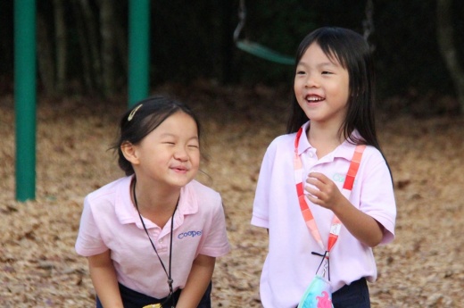Two girls in pink shirts smile
