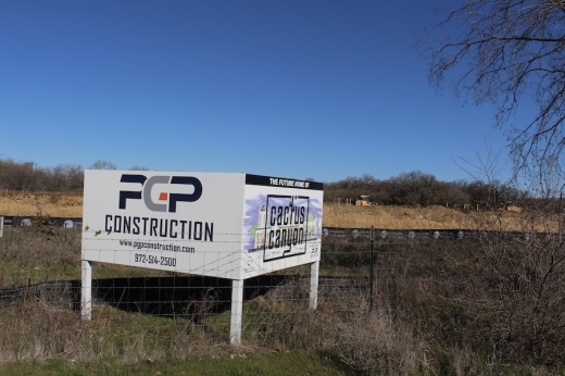 Picture of a sign noting a new restaurant is opening at a piece of land.