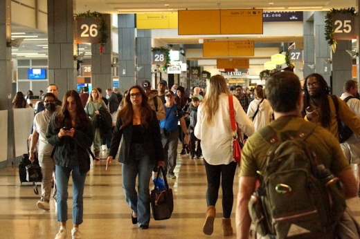 Travelers walking through the Barbara Jordan Terminal at Austin-Bergstrom International Airport near gates 25 and 26.