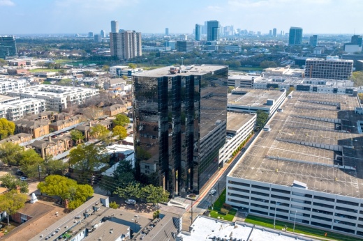 aerial photo of tall building with large glass windows on an urban street